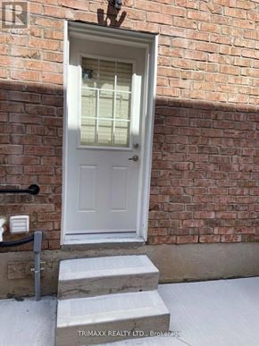 Caledon apartment for rent - A white door with a glass window is set in a brick wall.