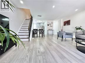 Kitchener townhouse for rent - A living room with a staircase and a dining area.