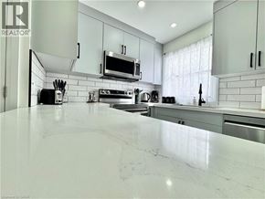 Kitchener townhouse for rent - A modern kitchen with white marble countertops and stainless steel appliances.