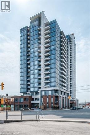 Kitchener apartment for rent - A modern multi-story building with a glass facade is under construction.