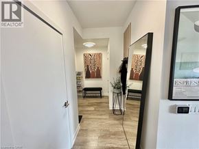Kitchener apartment for rent - A hallway with a white door and a framed picture on the wall.
