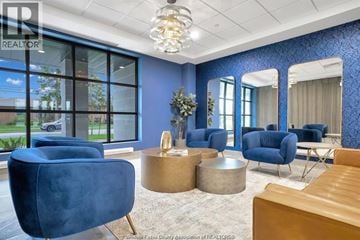 Windsor condo for rent - A living room with blue chairs and a wooden table.