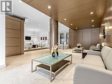 Toronto (Forest Hill North) condo for rent - A modern living room with a glass coffee table and a white sofa.