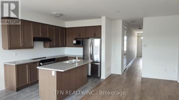 Welland (Dain City) apartment for rent - A kitchen with brown cabinets and a white countertop.