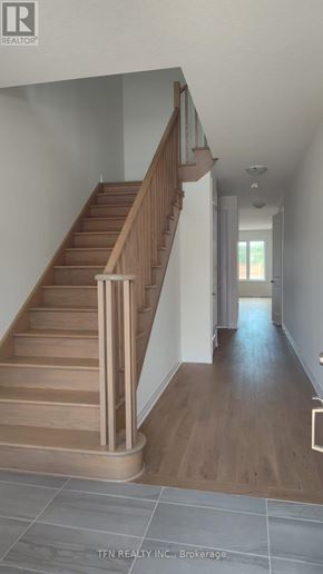Welland (Dain City) apartment for rent - A wooden staircase with a metal railing leads to a second floor.