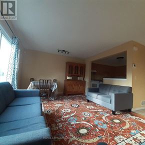Kitchener townhouse for rent - A living room with a blue couch and a rug with a floral pattern.