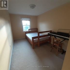 Kitchener townhouse for rent - A bedroom with a bed, chair, and piano.
