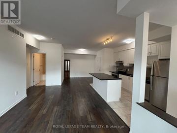 Ottawa condo for rent - A spacious kitchen with white cabinets and a dark wood floor.