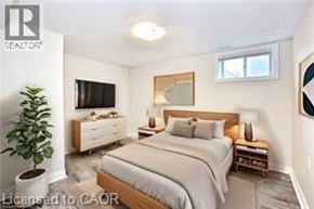 Hamilton apartment for rent - A bedroom with a bed, nightstand, and a plant.