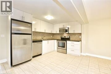 Hamilton apartment for rent - A kitchen with a refrigerator, microwave, oven, and sink.