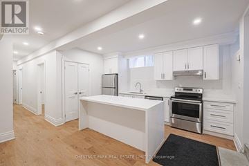 Toronto (South Riverdale) apartment for rent - A modern kitchen with white cabinets and stainless steel appliances.