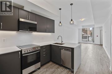 Toronto (Englemount-Lawrence) townhouse for rent - A modern kitchen with dark brown cabinets and stainless steel appliances.