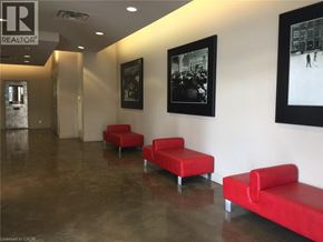 Kitchener condo for rent - A hallway with red seats and pictures on the wall.