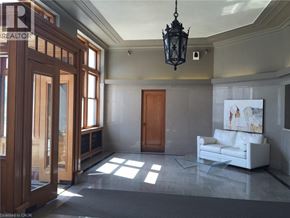 Kitchener condo for rent - A room with a white couch and a wooden door.