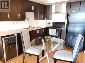 Toronto (Bendale) condo for rent - A kitchen with a table and chairs.