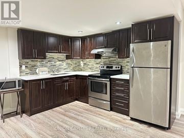 Richmond Hill (Harding) apartment for rent - A kitchen with wooden cabinets and a stone backsplash.