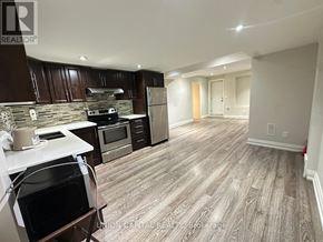Richmond Hill (Harding) apartment for rent - A kitchen with wooden cabinets and a stone backsplash.