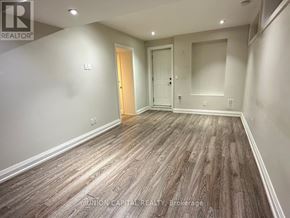 Richmond Hill (Harding) apartment for rent - A spacious room with wood flooring and two doors.