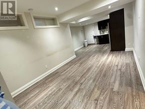 Richmond Hill (Harding) apartment for rent - A spacious room with wood flooring and a kitchen area in the background.