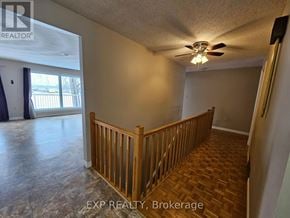 Deseronto (Deseronto (Town)) apartment for rent - A room with a wooden railing and a ceiling fan.
