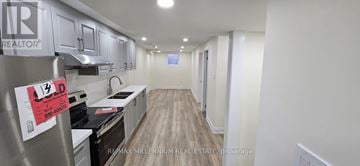 Brampton (Northwest Brampton) townhouse for rent - A kitchen with a stove top oven and a refrigerator with a sign on it.
