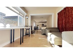White Rock apartment for rent - A living room with a white couch and a dining table with chairs.