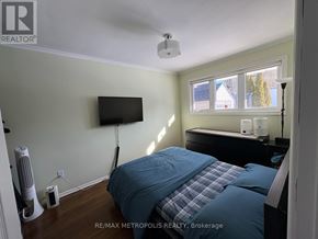 Oshawa (Eastdale) apartment for rent - A bedroom with a bed, a television, and a window.