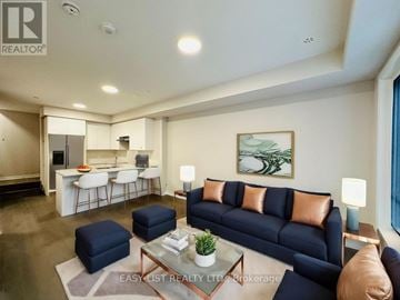 Bradford West Gwillimbury (Bradford) townhouse for rent - A living room with a dark blue sofa and a glass coffee table.