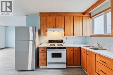 Plympton-Wyoming apartment for rent - A kitchen with wooden cabinets and a white stove top oven.