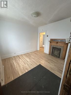 Toronto (South Parkdale) multi-family for rent - A room with a fireplace and wood flooring.
