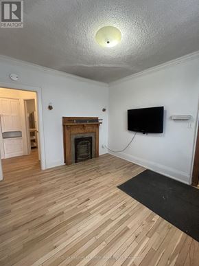 Toronto (South Parkdale) multi-family for rent - A living room with a fireplace and a flat screen TV.