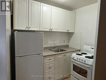 Toronto (Yonge-St. Clair) house for rent - A kitchen with white cabinets and appliances.