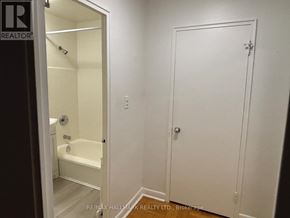 Toronto (Yonge-St. Clair) house for rent - A white bathroom with a door and a bathtub.