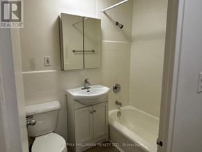 Toronto (Yonge-St. Clair) house for rent - A white bathroom with a toilet, sink, and bathtub.