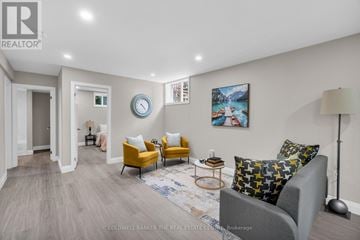 Barrie (Little Lake) apartment for rent - A living room with a grey couch, yellow chairs, and a painting on the wall.