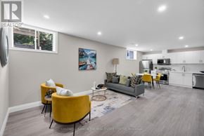 Barrie (Little Lake) apartment for rent - A real estate listing image of a modern living room with a kitchen in the background.