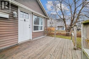 Hamilton apartment for rent - A wooden deck leads to a white door on a house with a realtor sign.