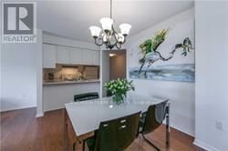 Toronto (Bay Street Corridor) condo for rent - A dining room with a table and chairs and a painting of a tree on the wall.
