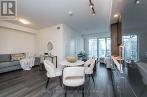 Toronto (Waterfront Communities) condo for rent - A modern living room with a grey sofa, white chairs, and a dining table.