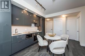 Toronto (Waterfront Communities) condo for rent - A modern kitchen with a dining table and chairs.