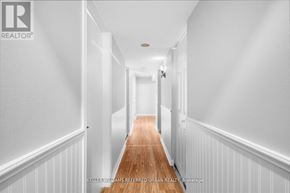 Toronto (Centennial Scarborough) apartment for rent - A long hallway with white walls and wood flooring.