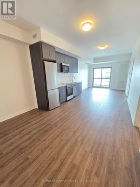 Clarington (Bowmanville) condo for rent - A kitchen with a refrigerator, microwave, and oven.