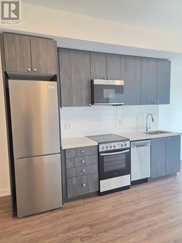 Clarington (Bowmanville) condo for rent - A modern kitchen with a stainless steel refrigerator and oven.