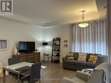 Ottawa condo for rent - A modern living room with a grey sofa and a glass table.