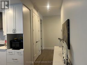 Ottawa condo for rent - A kitchen with white cabinets and a black microwave.