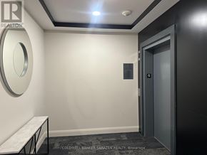 Ottawa condo for rent - A hallway with a round mirror on the wall and a door on the right.