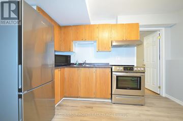 Barrie (Grove East) apartment for rent - A kitchen with wooden cabinets and stainless steel appliances.