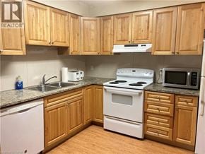Waterloo condo for rent - A kitchen with wooden cabinets and white appliances.