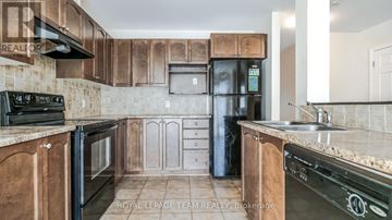 Ottawa townhouse for rent - A kitchen with wooden cabinets and a black fridge.