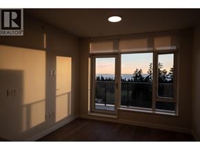 Vancouver apartment for rent - A room with a window overlooking a forest at dusk.